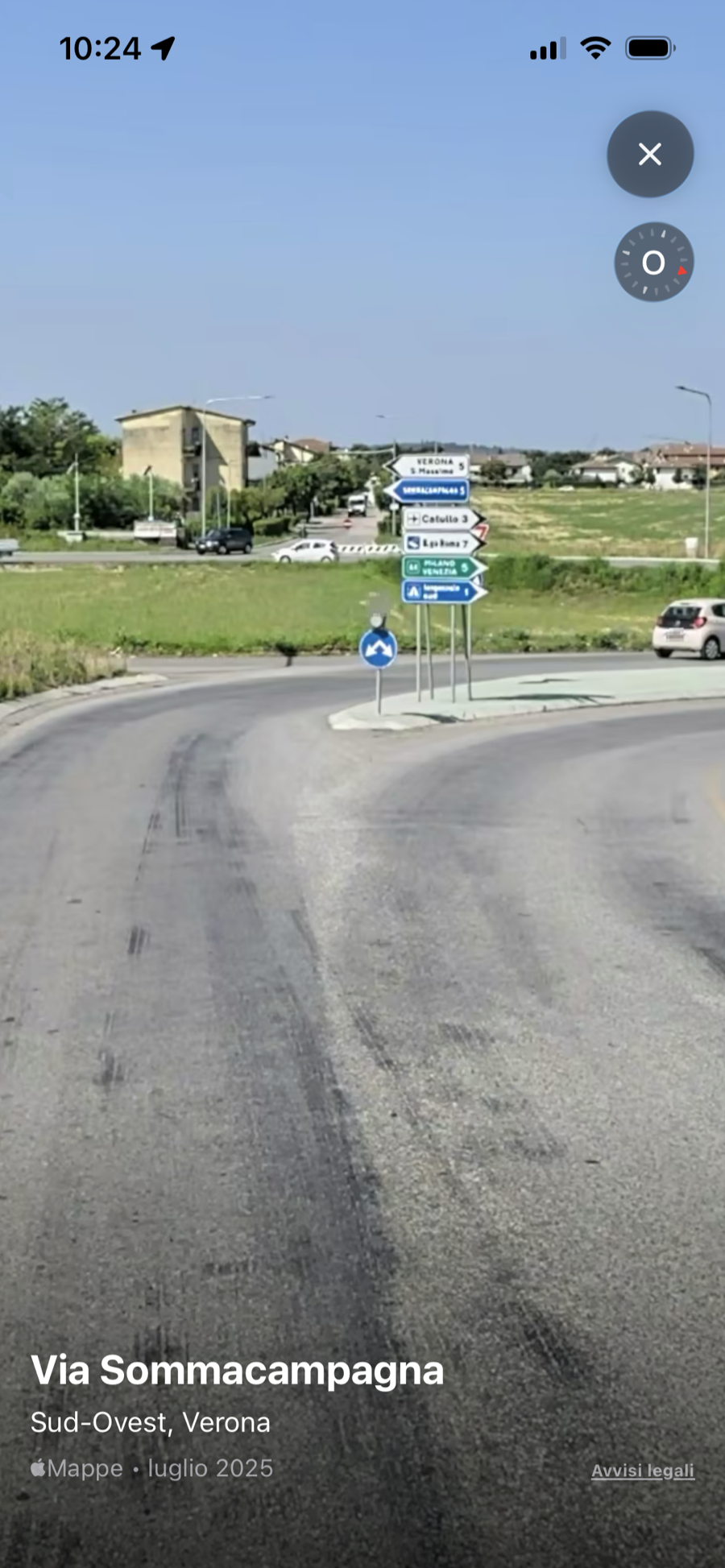 La vista dalla strada a Via Sommacampagna, con i cartelli verdi e azzurri dello svincolo.